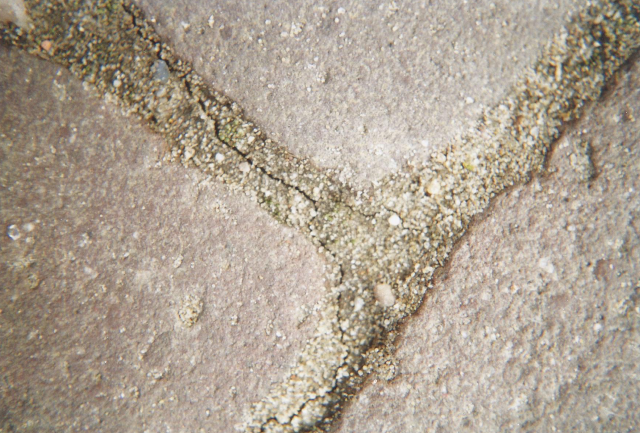 Macrofoto van een uitgedroogde en daardoor gescheurde zandvoeg tussen twee stenen